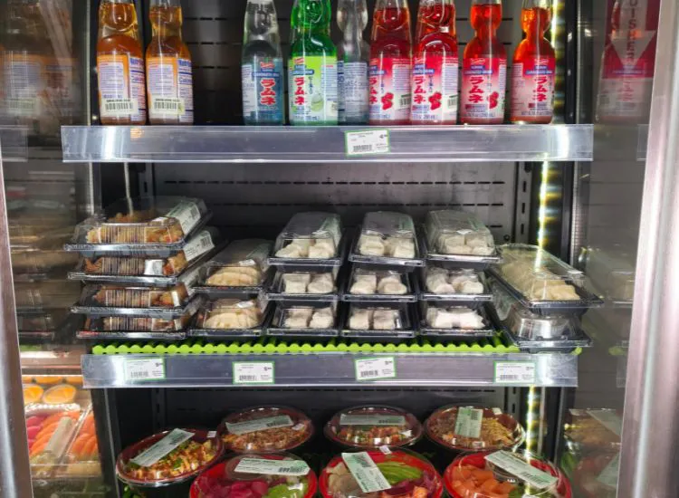 Hashi Sushi refrigerated case displaying nigiri, rolls, poke bowls, and combination trays at Sunset Foods